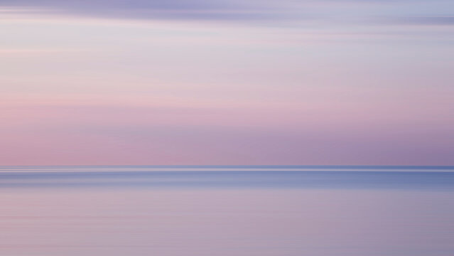 Blurred background sea and sky at sunrise. The sea and the sky are pearly. Beautiful backdrop for your design.