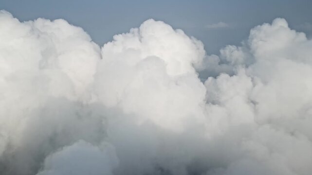 Massive white cumulus clouds against a blue sky