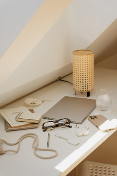 Cozy Attic Desk Essentials With Laptop And Rattan Lamp
