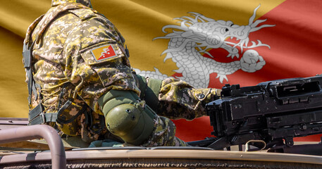 Obraz premium Bhutan flag with soldier at machine gun turret in front of it. Closeup side view.
