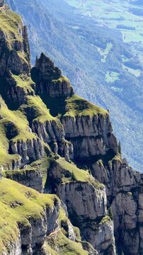 Dramatic view from Ch&auml;serrugg over steep cliffs toward Walenstadt, Flums and the Seez Valley in Switzerland, revealing the extreme drop and rugged terrain of the Churfirsten mountains.