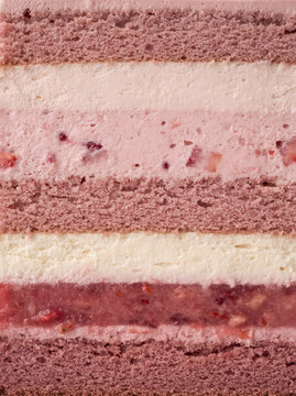 Close-up of a pink strawberry layered cake featuring fluffy sponge, smooth cream, and strawberry filling, highlighting rich textures and elegant dessert layers.