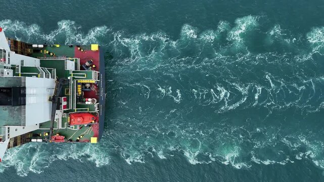 Aerial top view of cargo ship with contrail in the ocean sea ship carrying container and running from container international port smart freight shipping by ship service