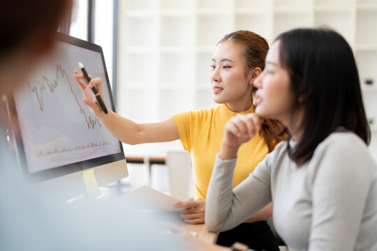 Asian Businesswoman Pointing Pen at Financial Stock Chart Screen