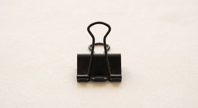 Single Black Binder Clip Isolated on Neutral Background