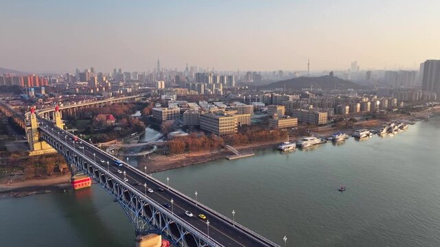 Aerial view of Nanjing Yangtze River Bridge with traffic and city skyline at sunrise in Nanjing, China