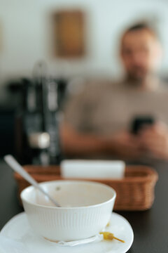 Empty Soup Bowl On Restaurant Table With Male Client. Finished soup bowl sits on a table with a customer