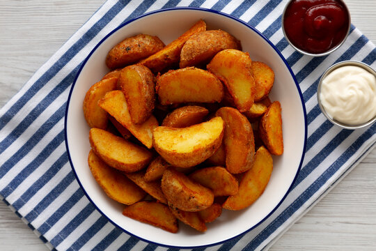 Homemade Potato Wedges with Ketchup and Mayonnaise, top view.