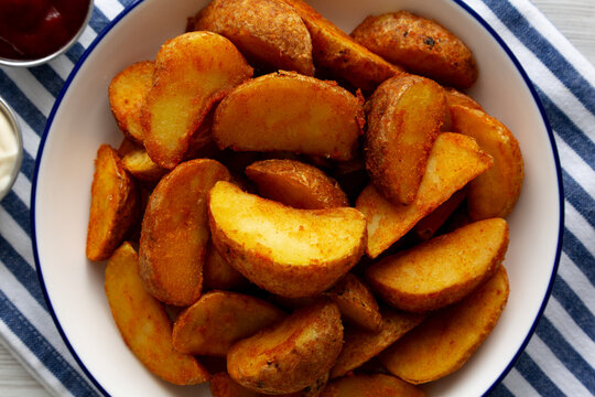 Homemade Potato Wedges with Ketchup and Mayonnaise, top view.