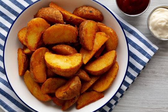 Homemade Potato Wedges with Ketchup and Mayonnaise, top view.