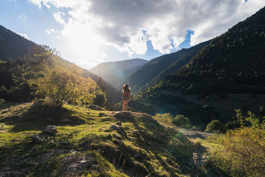 Woman hiking mountain exploring vast valley landscape