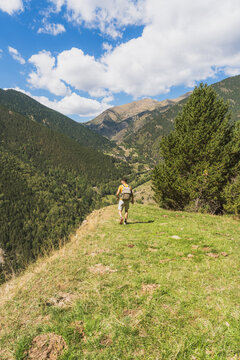 Man hiking mountain path discovering beautiful valley landscape