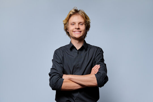 Smiling young man with arms crossed portrait studio