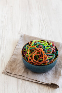 Colorful Spaghetti Jelly Candies Sprinkled with Sugar in a Bowl, side view. Copy space.