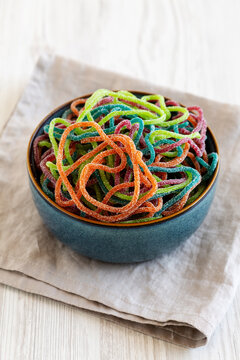 Colorful Spaghetti Jelly Candies Sprinkled with Sugar in a Bowl, side view.