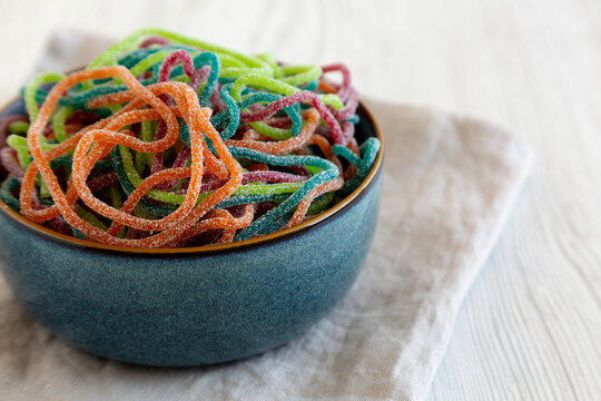 Colorful Spaghetti Jelly Candies Sprinkled with Sugar in a Bowl, side view.