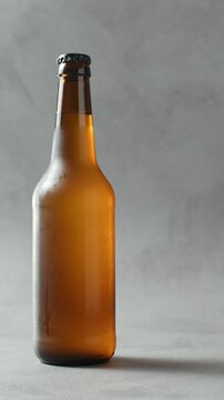 Amber cider bottle stands on neutral background for alcoholic and nonalcoholic drink advertising.