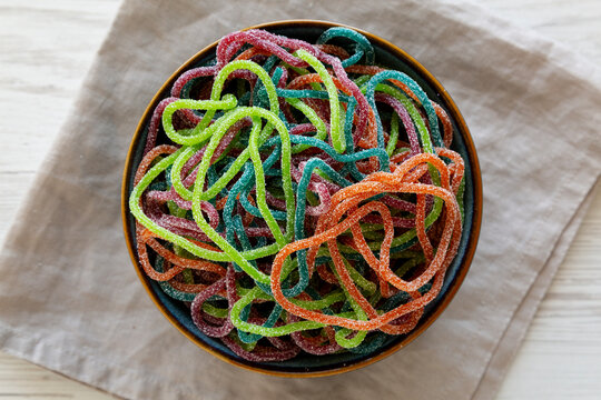 Colorful Spaghetti Jelly Candies Sprinkled with Sugar in a Bowl, top view.