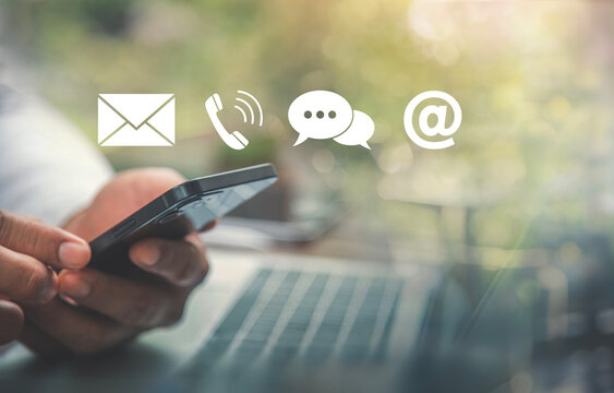 Contact Us Concept with Hands Holding Smartphone and Floating Communication Icons.