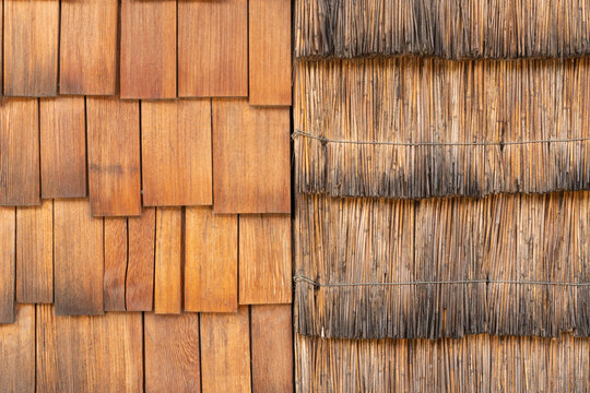 Abstract background texture of rustic wooden shingles and thatched straw roof side by side.