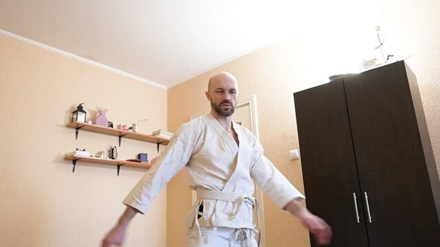 Martial artist practicing karate movements in home environment interior
