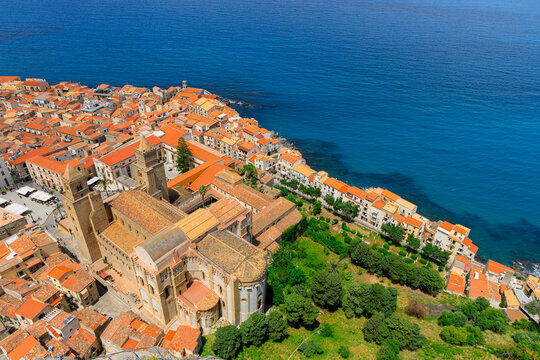 Aerial view of a historic medieval coastal town with a grand cathedral and terracotta rooftops