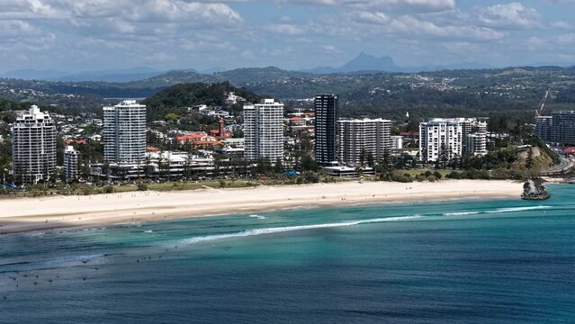 Aerial view of Coolangatta beach with high-rise buildings, turquoise ocean, and sandy coastline in Coolangatta, Queensland, Australia.