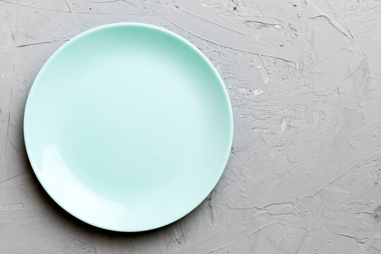 Top view of empty blue plate on cement background. Empty space for your design