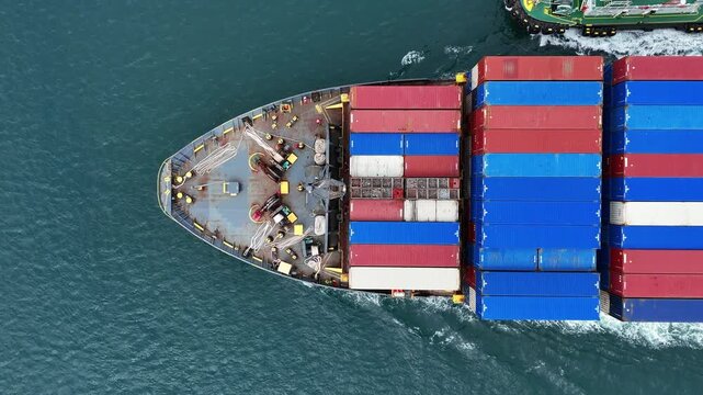 Aerial top view of cargo ship with contrail in the ocean sea ship carrying container and running from container international port smart freight shipping by ship service
