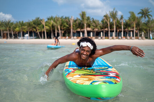 Happy young couple sharing a joyful moment on surfboards during a tropical vacation