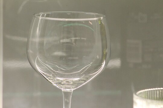 Elegant empty wine glass photographed with soft lighting and subtle reflections against a neutral background. Ideal for restaurant, bar, hospitality, luxury, dining, beverage, and lifestyle themes.