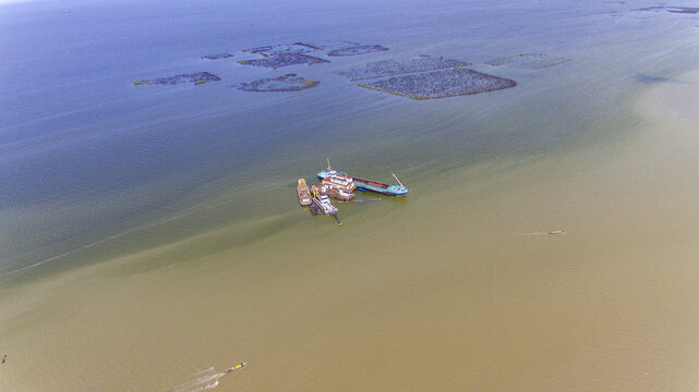 Aerial view of a dredging vessel working in the waters of Lagos Lagoon with surrounding fish farms in Oworonshoki, Lagos, Nigeria.