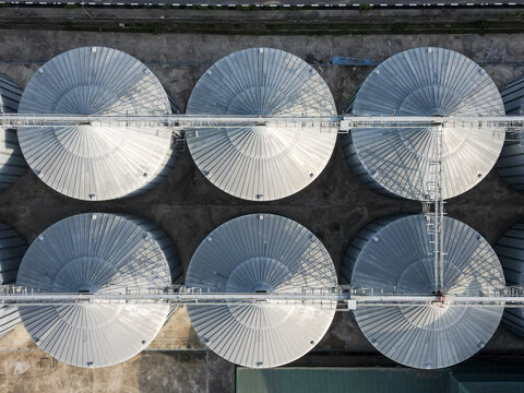 Aerial view of the Lagos Rice Mill featuring large metallic grain silos arranged in a grid pattern with industrial walkways and concrete ground in Imota, Lagos, Nigeria.