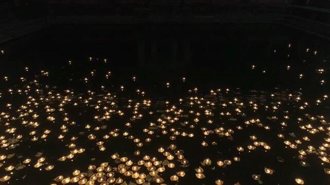 Thousands of Floating Clay Diyas and Oil Lamps on Calm Dark Water at Night with Glowing Reflections for Diwali and Dev Deepawali