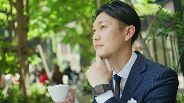 Japanese businessman taking a coffee break outdoors between meetings