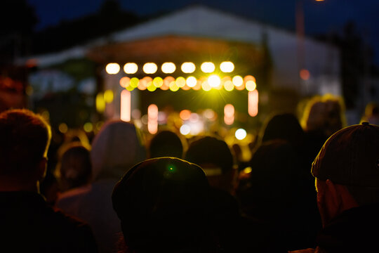People watching live music at an outdoor concert at night