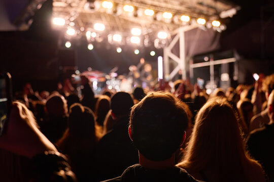 Crowd watching live outdoor concert at night