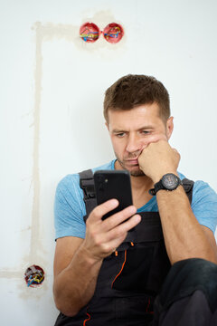 Worried man searching repair advice online during renovation
