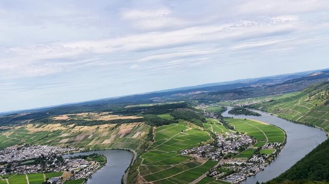 Spektakul&auml;re Luftaufnahme der Moselschleife bei P&ouml;lich und Mehring. Gr&uuml;ne Weinberge s&auml;umen das tiefblaue Flussufer unter leicht bew&ouml;lktem Sommerhimmel in der Urlaubsregion Mosel.