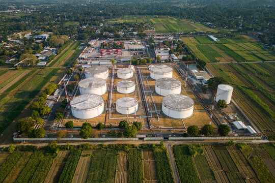 Aerial view of a fuel storage facility with large white cylindrical tanks surrounded by agricultural fields and rural landscape in Boyolali, Central Java, Indonesia.
