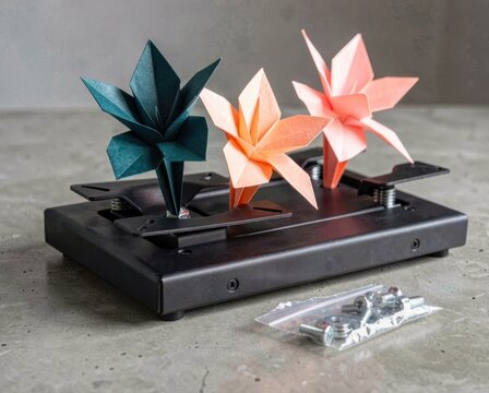 Three colorful origami flowers mounted on a black metal base