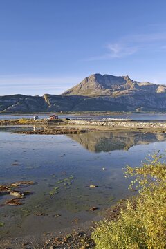 Rocky mountain reflected in water, fjord at low tide, Offers&ouml;y, FV 17, Kystriksveien, Nordland, Norway