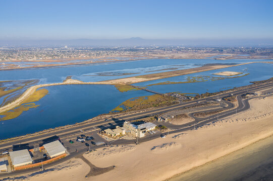 Aerial view of the Bolsa Chica Ecological Reserve featuring wetlands, coastal roads, and sandy terrain in Huntington Beach, California, United States.