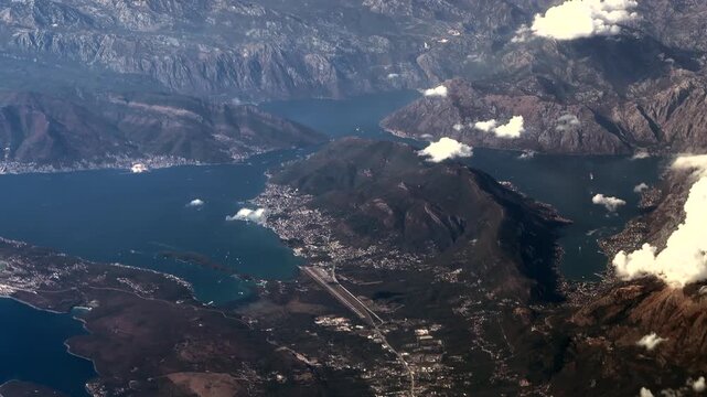 4k aerial video footage, overflying landscape around city of Tivat, a town in the coastal region of Montenegro, located in the Bay of Kotor with Tivat Airport, City of Tivat and mountain landscape