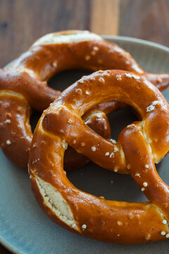 Freshly Baked Salted Soft Pretzels - bavarian lye brown pastry - on Wooden Board
