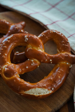 Freshly Baked Salted Soft Pretzels - bavarian lye brown pastry - on Wooden Board