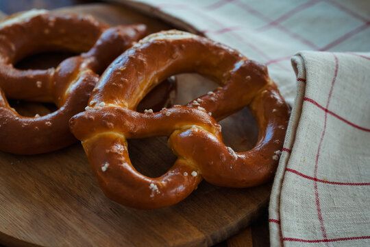 Freshly Baked Salted Soft Pretzels - bavarian lye brown pastry - on Wooden Board
