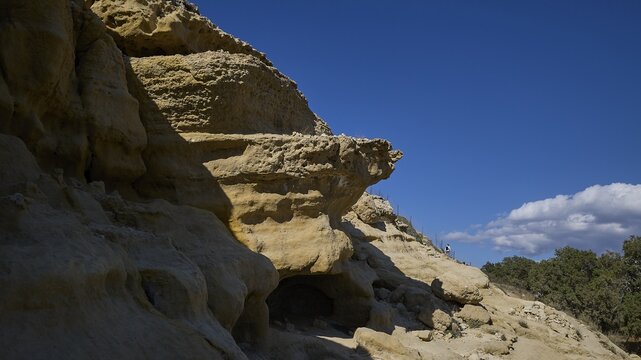 Neolithic caves, former hippie paradise, dramatic rock formations in sunlight with clear blue sky and few shadows, Matala, south coast, Crete, Greek islands, Greece