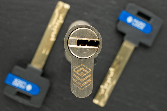 Mortise lock cylinder mechanism with keys on a piece of slate, macro shot.