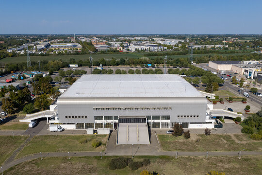 Aerial view of the PalaPanini sports arena in Modena, featuring its large metallic roof, surrounding parking areas, and industrial landscape in Modena, Emilia-Romagna, Italy.
